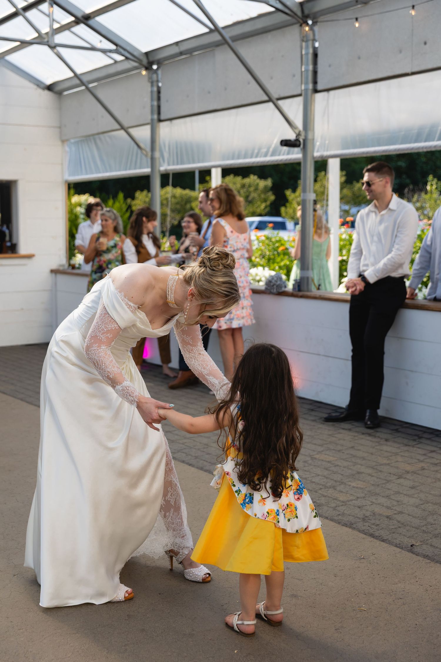 A series of four photos showing people dancing and celebrating at a wedding reception under a covered outdoor venue.