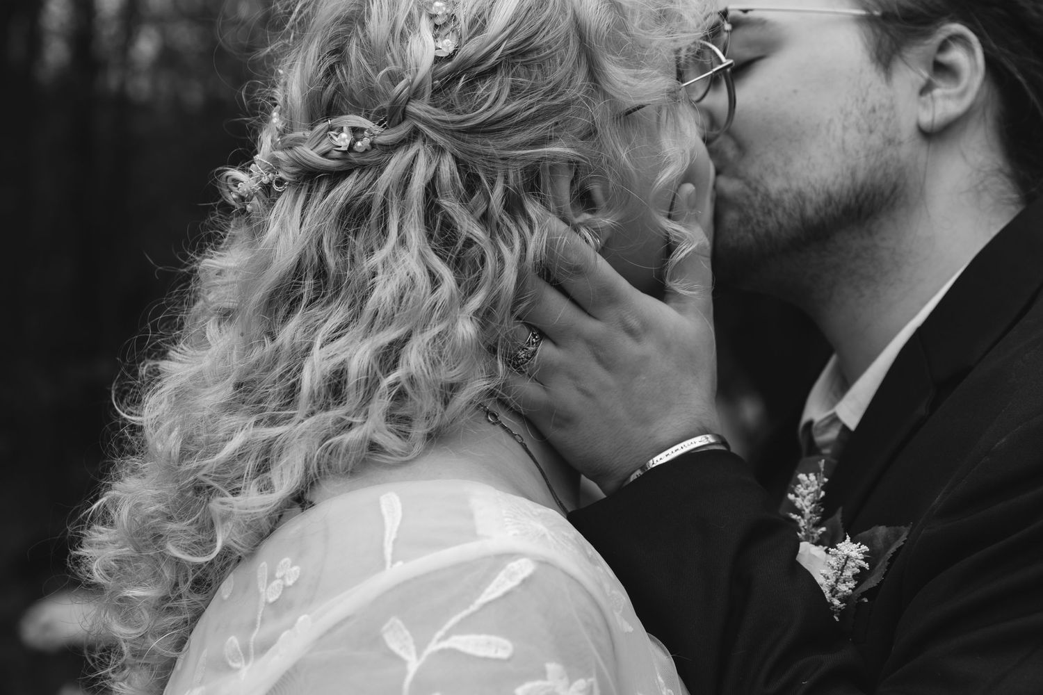 Intimate black and white wedding portrait with curly hair detail.