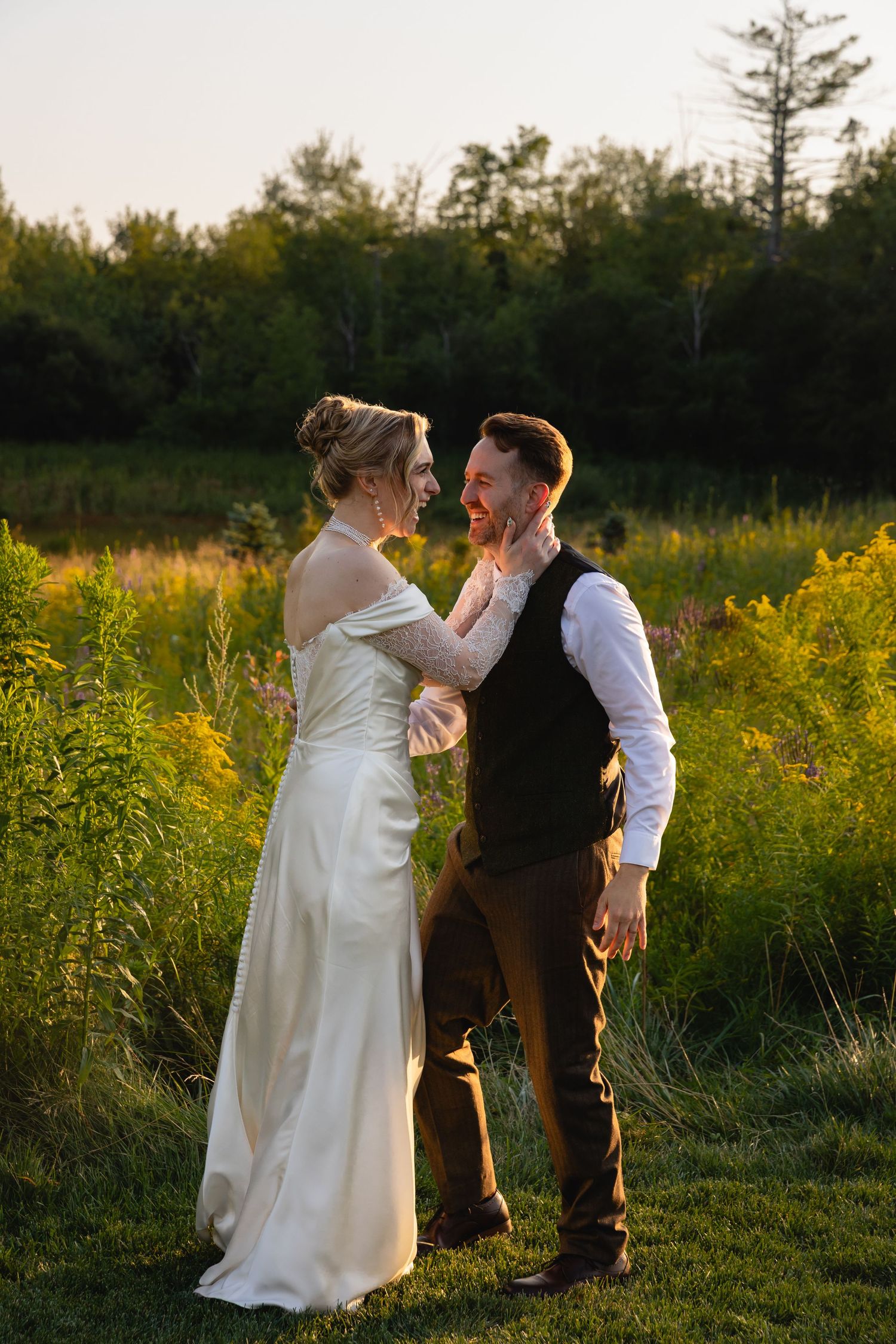 A couple dances playfully in a meadow of yellow wildflowers during golden hour.