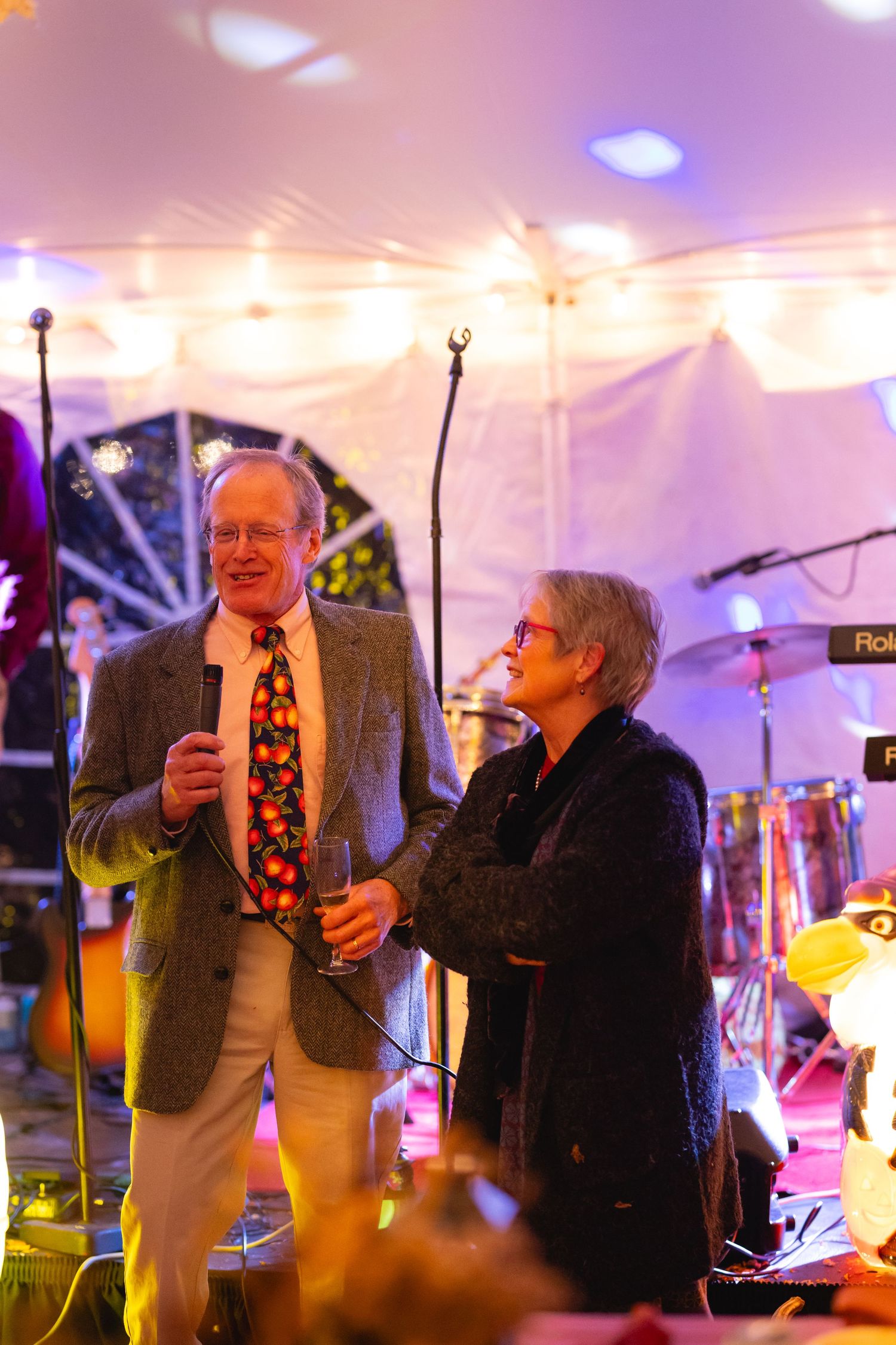 A sequence of candid party photos showing people dancing and celebrating under purple and warm lighting in a tent venue.
