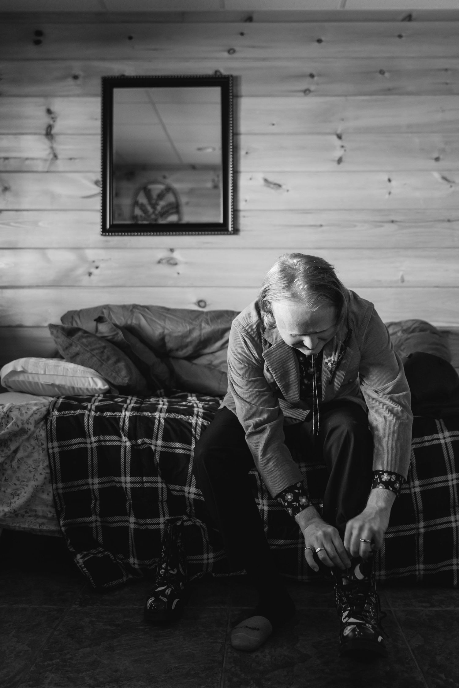 A black and white sequence showing someone lying down and rolling across a plaid couch or sofa.
