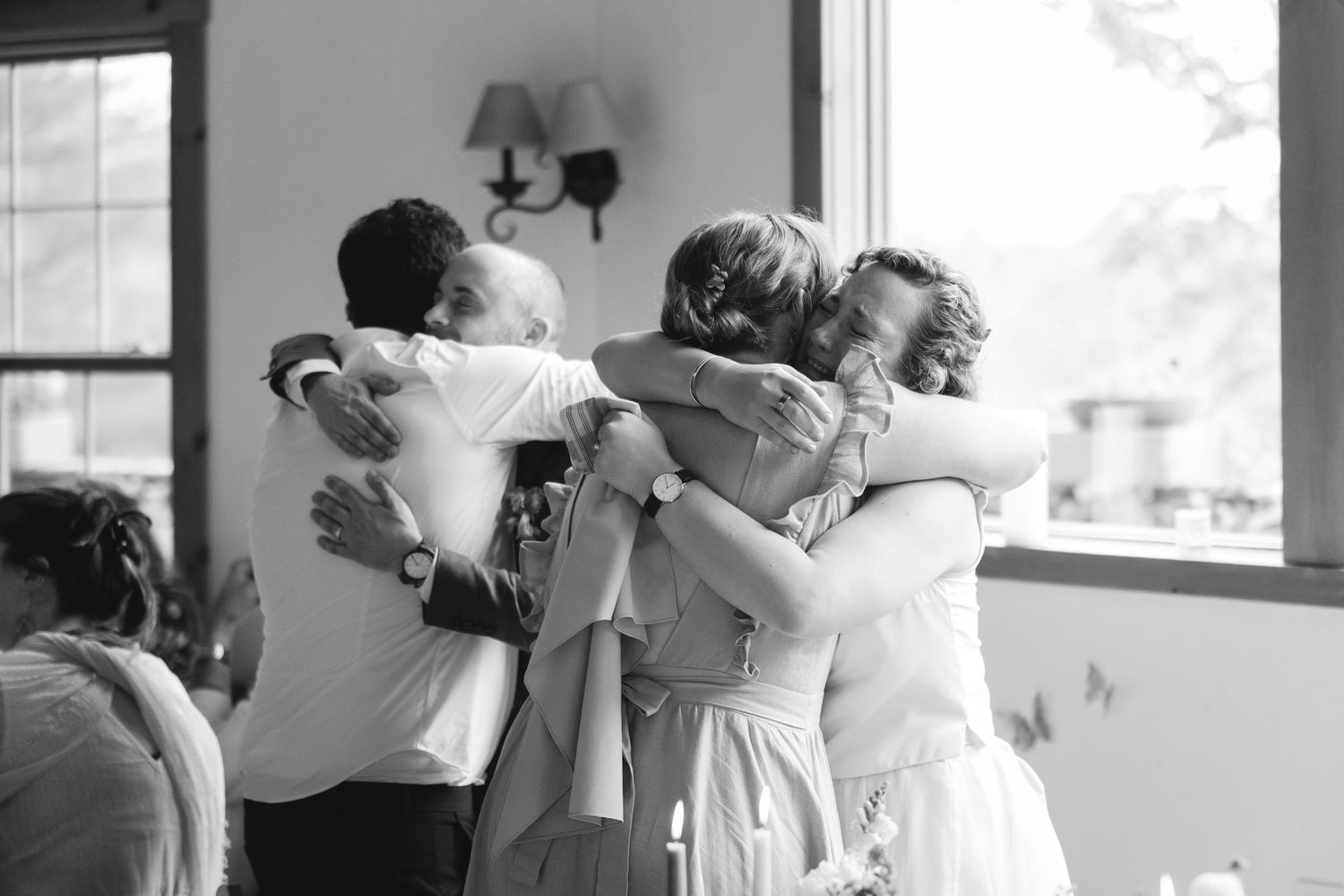 A black and white photograph of couples dancing together in an intimate indoor setting.