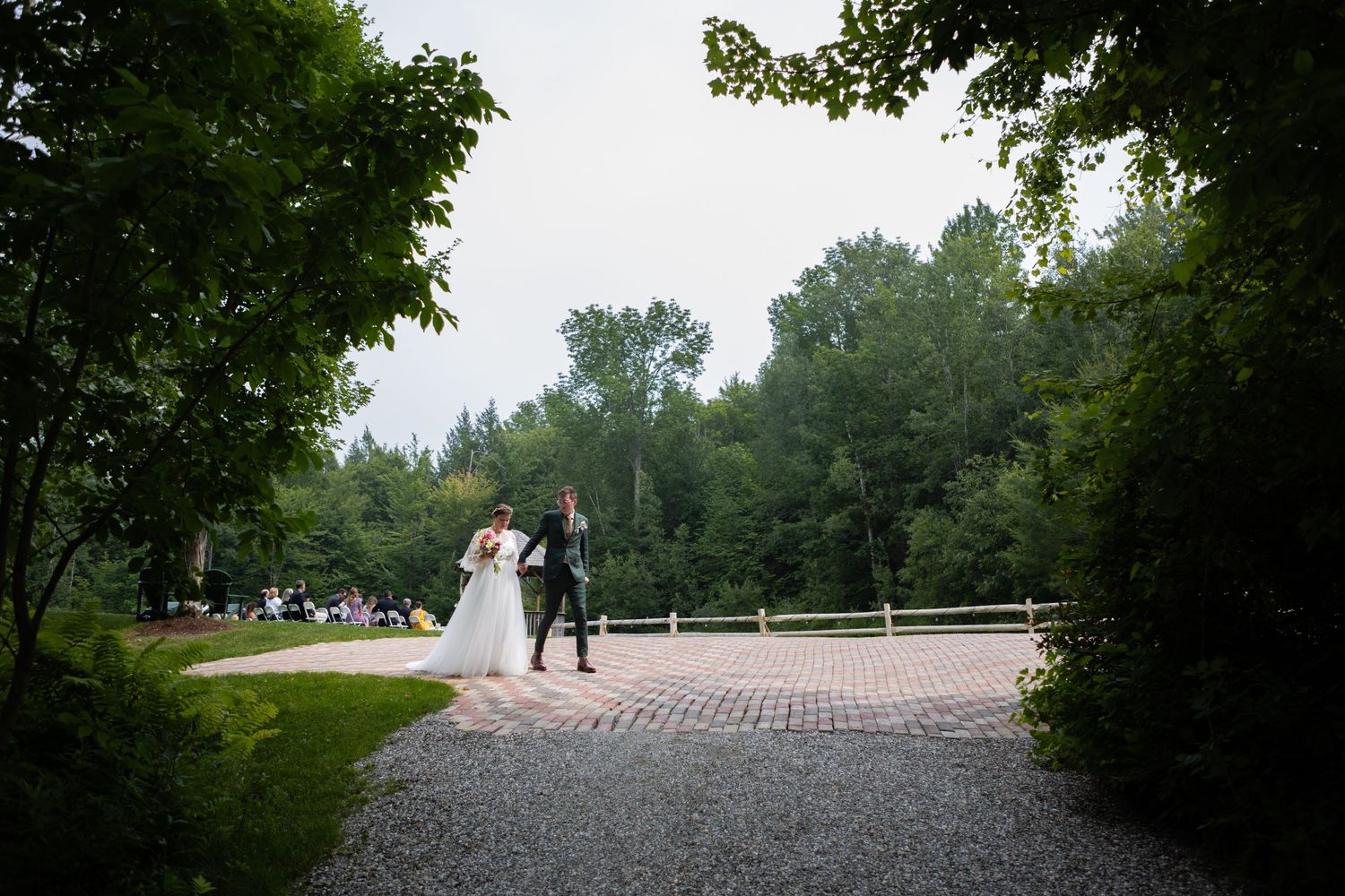 Wedding couple walks along a winding path through lush gardens on their special day.