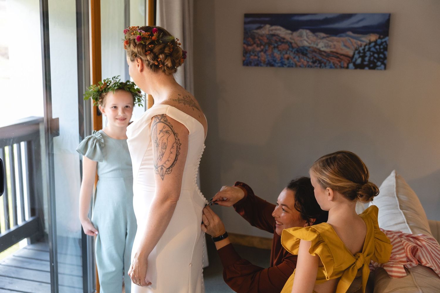 Wedding preparation scene with people gathered on a balcony in pastel dresses.