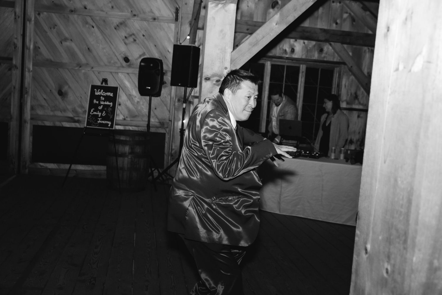 Vintage black and white photo of someone dancing energetically in a shiny outfit at what appears to be a dance hall.