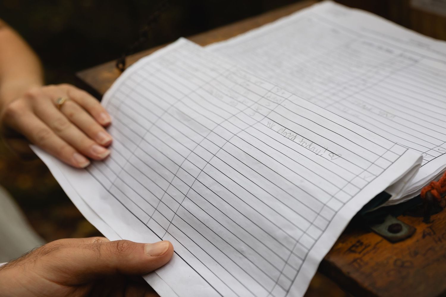 Close-up view of hands reviewing paperwork documents.