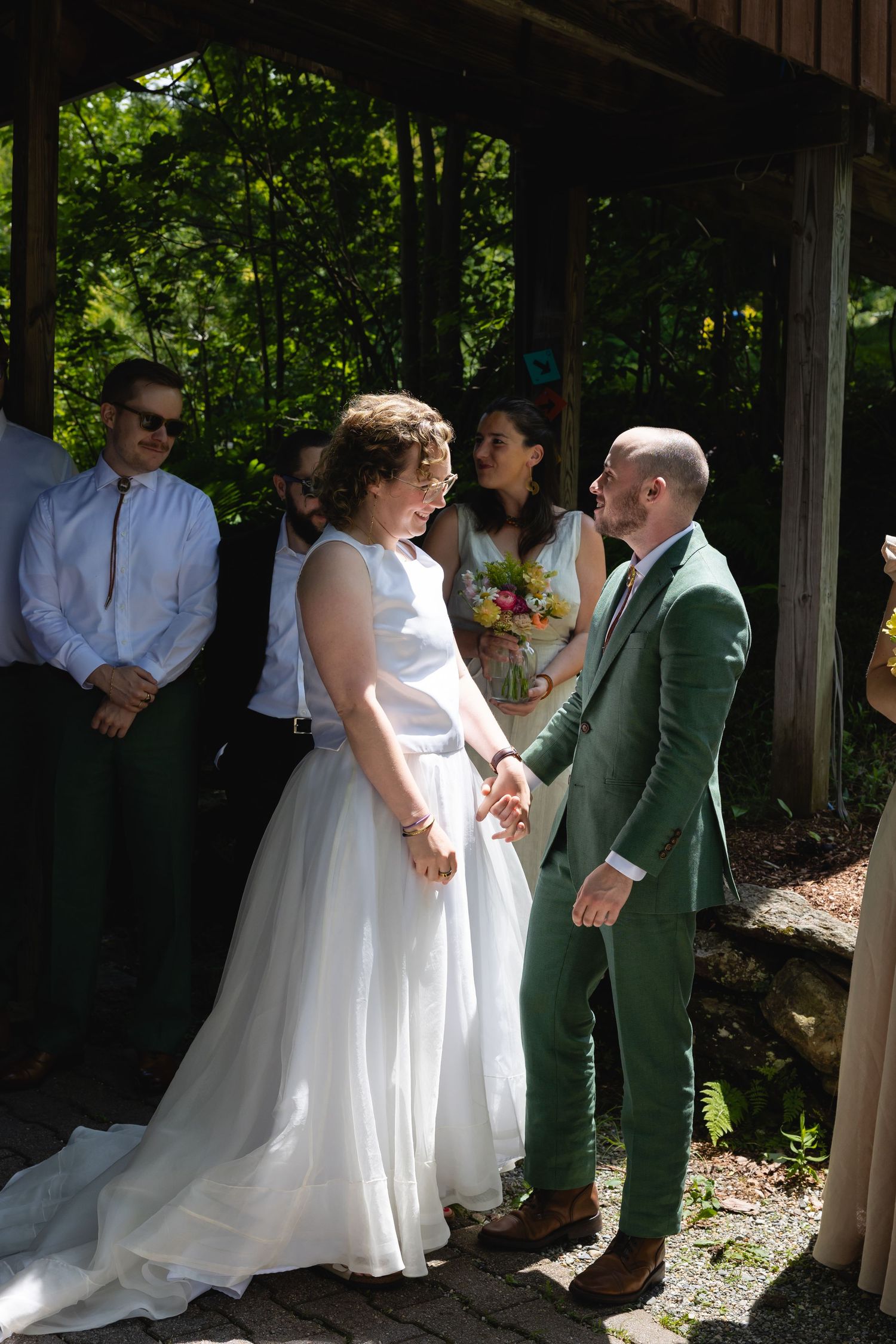 A couple shares a romantic dance moment under a covered outdoor venue during their wedding celebration.