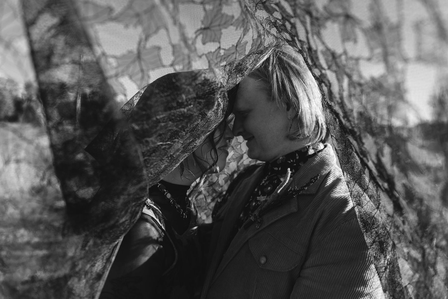 Artistic black and white portrait of someone exhaling smoke against a textured wall background.