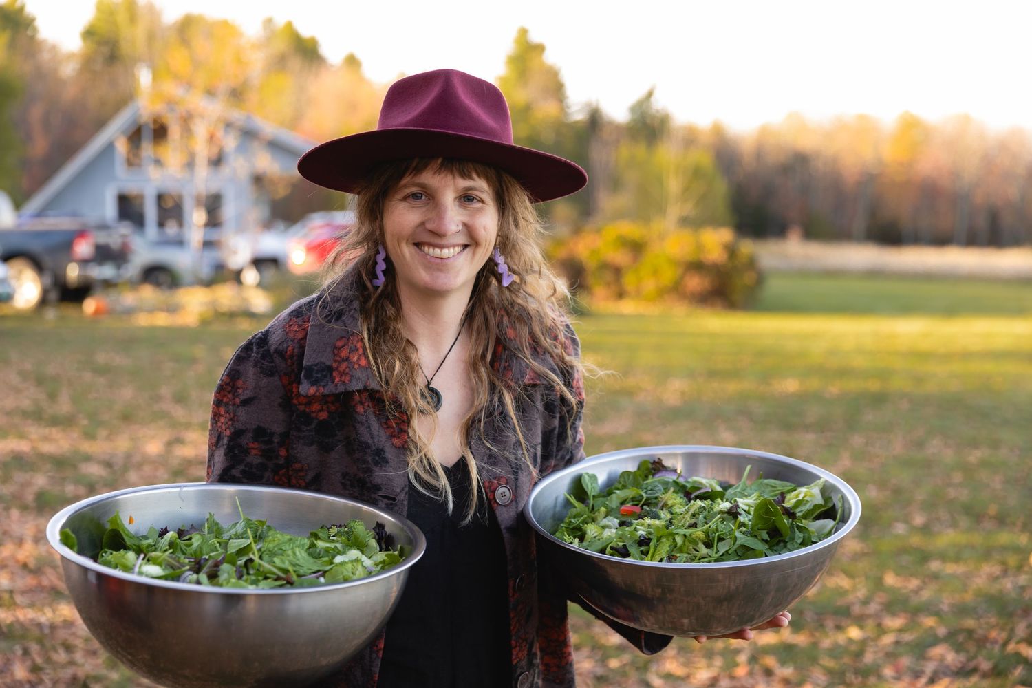 A farmer harvests fresh organic salad greens from a sustainable garden during golden hour sunset.