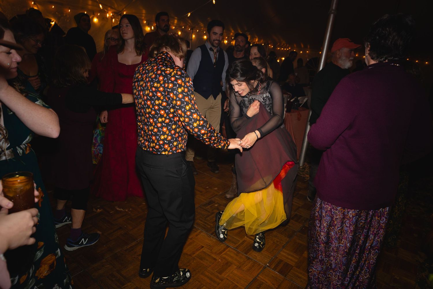 People dancing together at a dimly lit nighttime social gathering or party.
