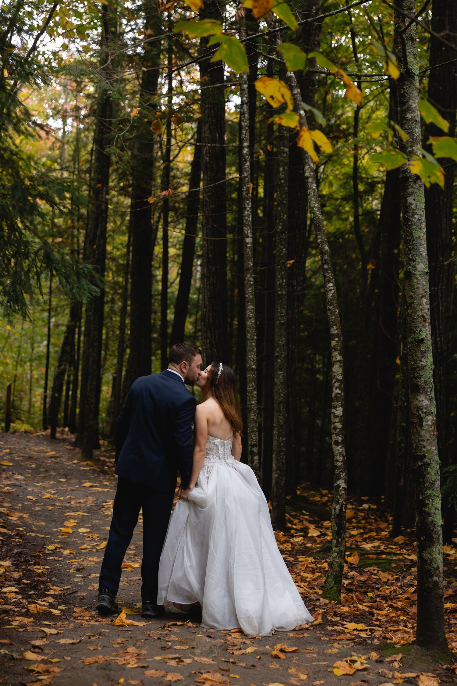 Romantic autumn forest wedding scene with fallen leaves.