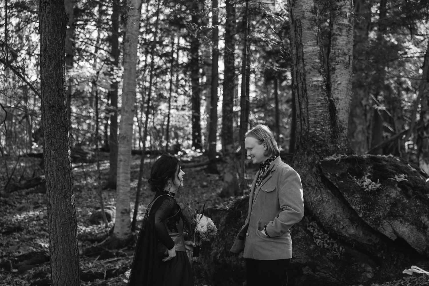A group walks through a serene forest path surrounded by tall trees on a misty day.