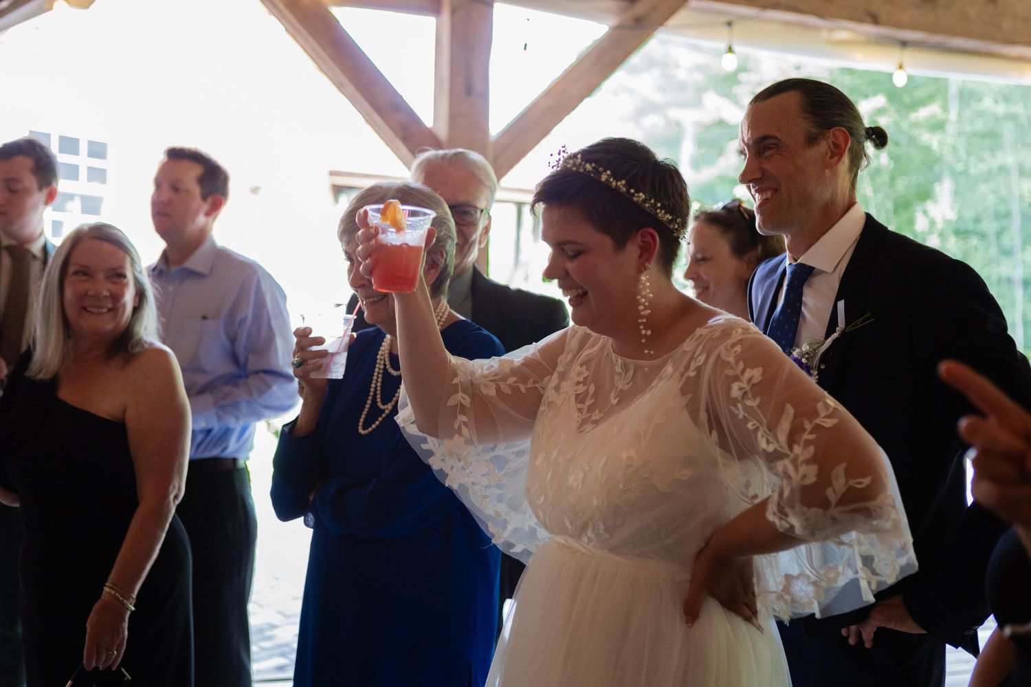 A celebratory moment during a wedding reception in a rustic venue.