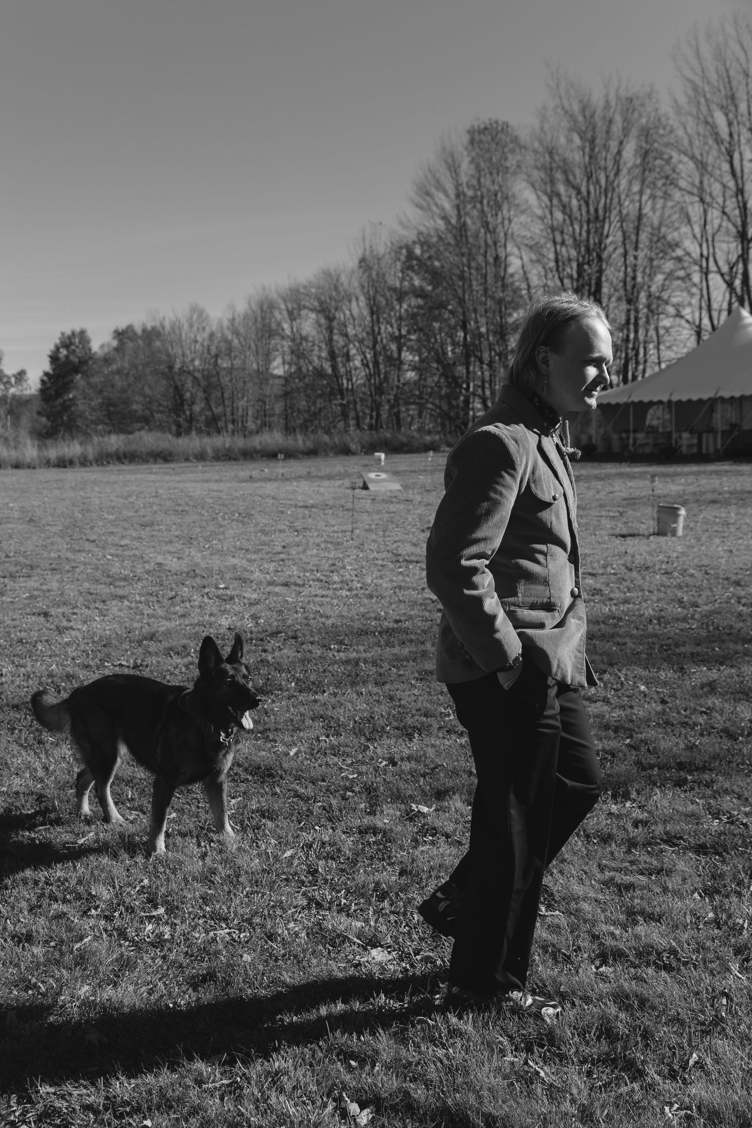 A black and white photo series shows someone playing with a dog in a grassy field on a winter day.