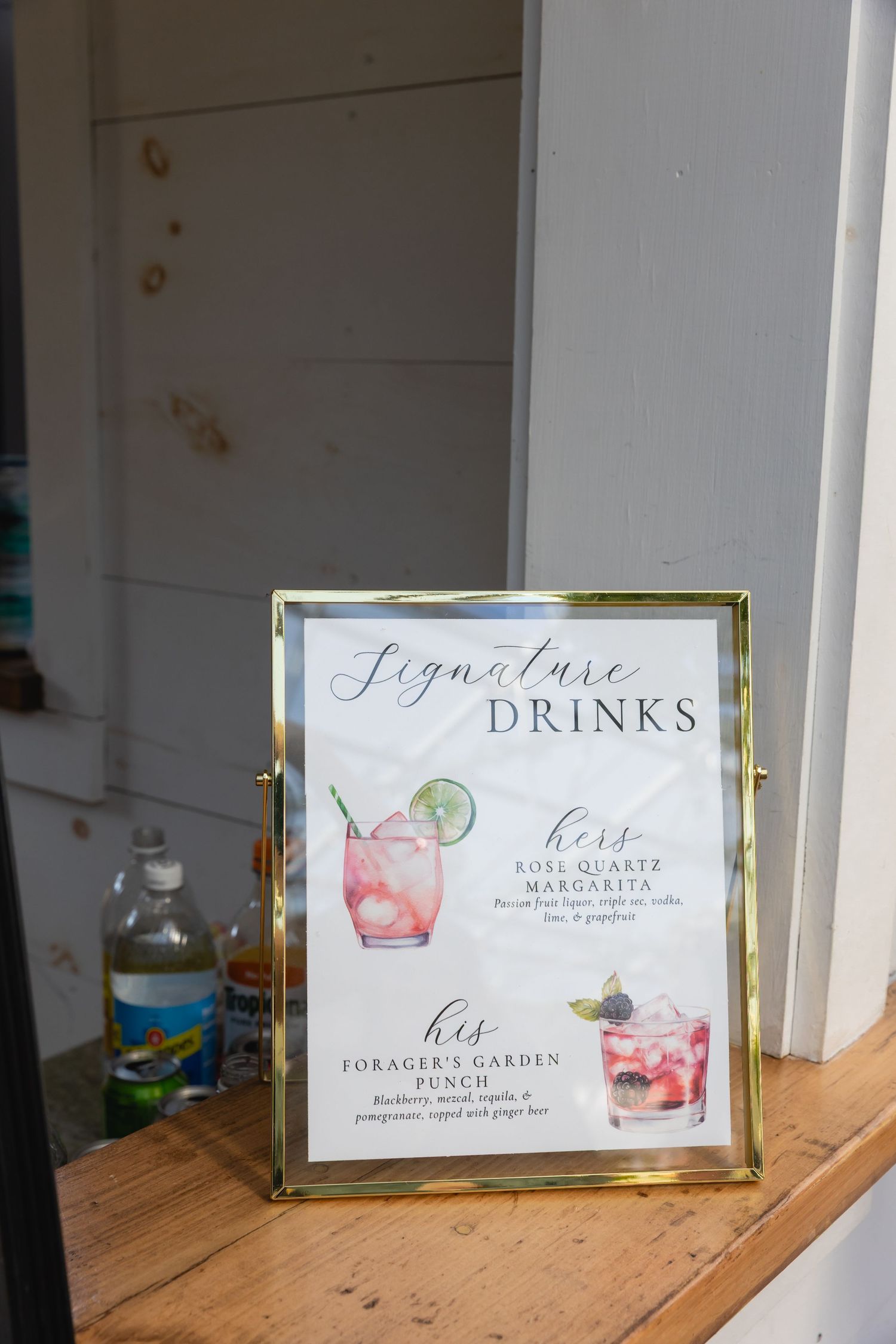 Framed signature drinks menu card displaying cocktail options at an event.