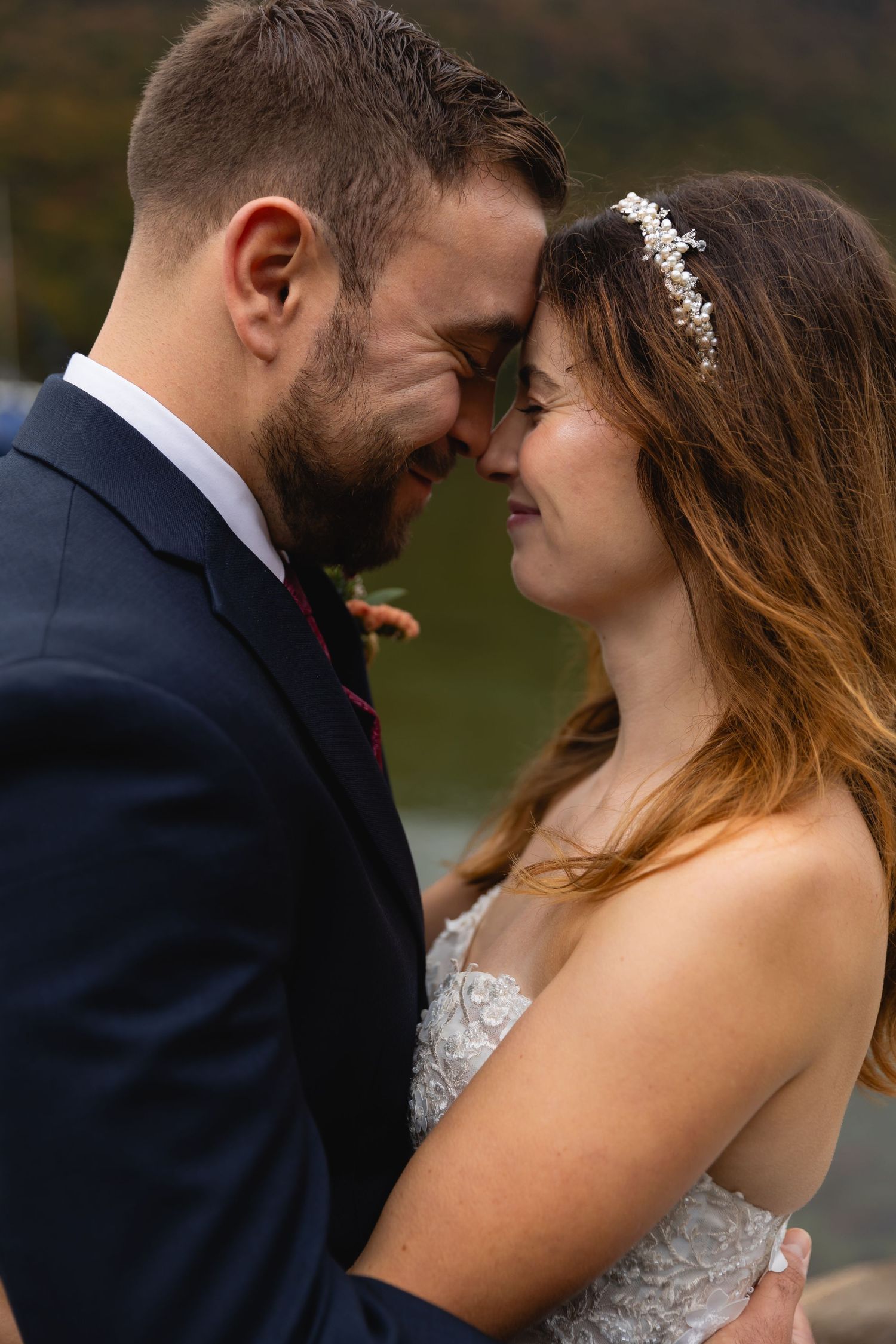 Intimate moment between newlyweds against autumn mountain landscape.