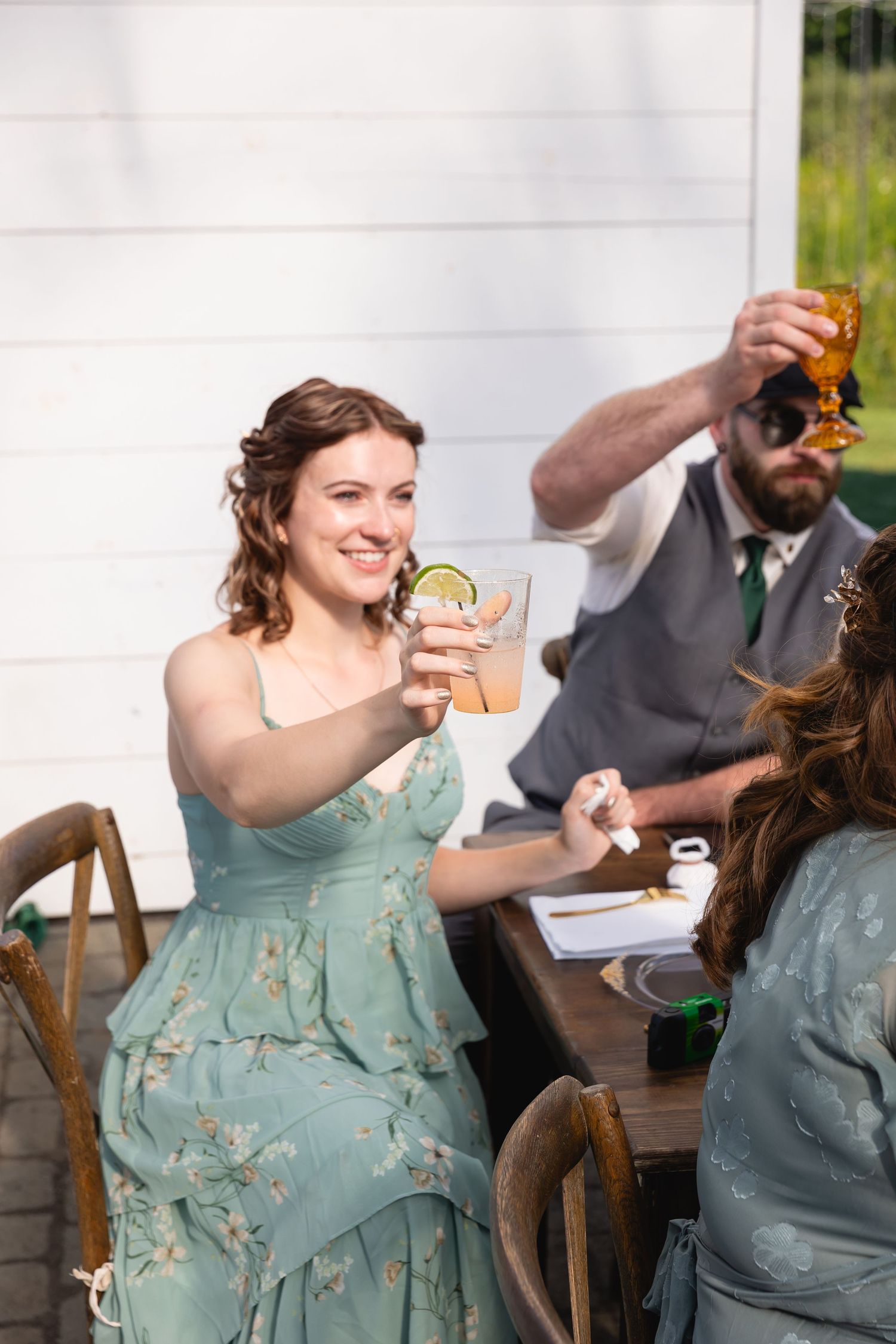People enjoying drinks and conversation at a sunny outdoor party.