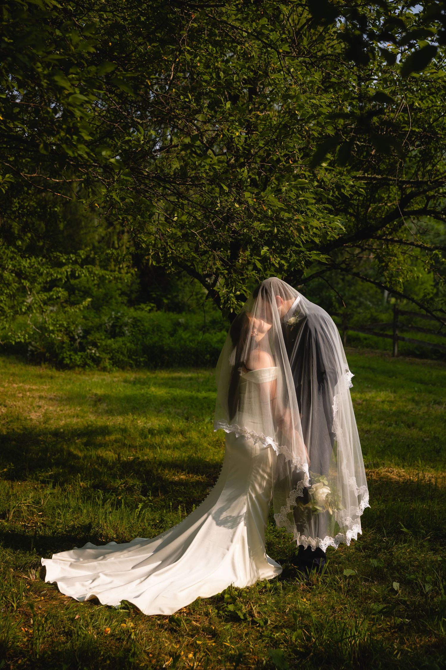 A romantic wedding photo sequence showing a couple in white embracing under trees in a lush garden setting.