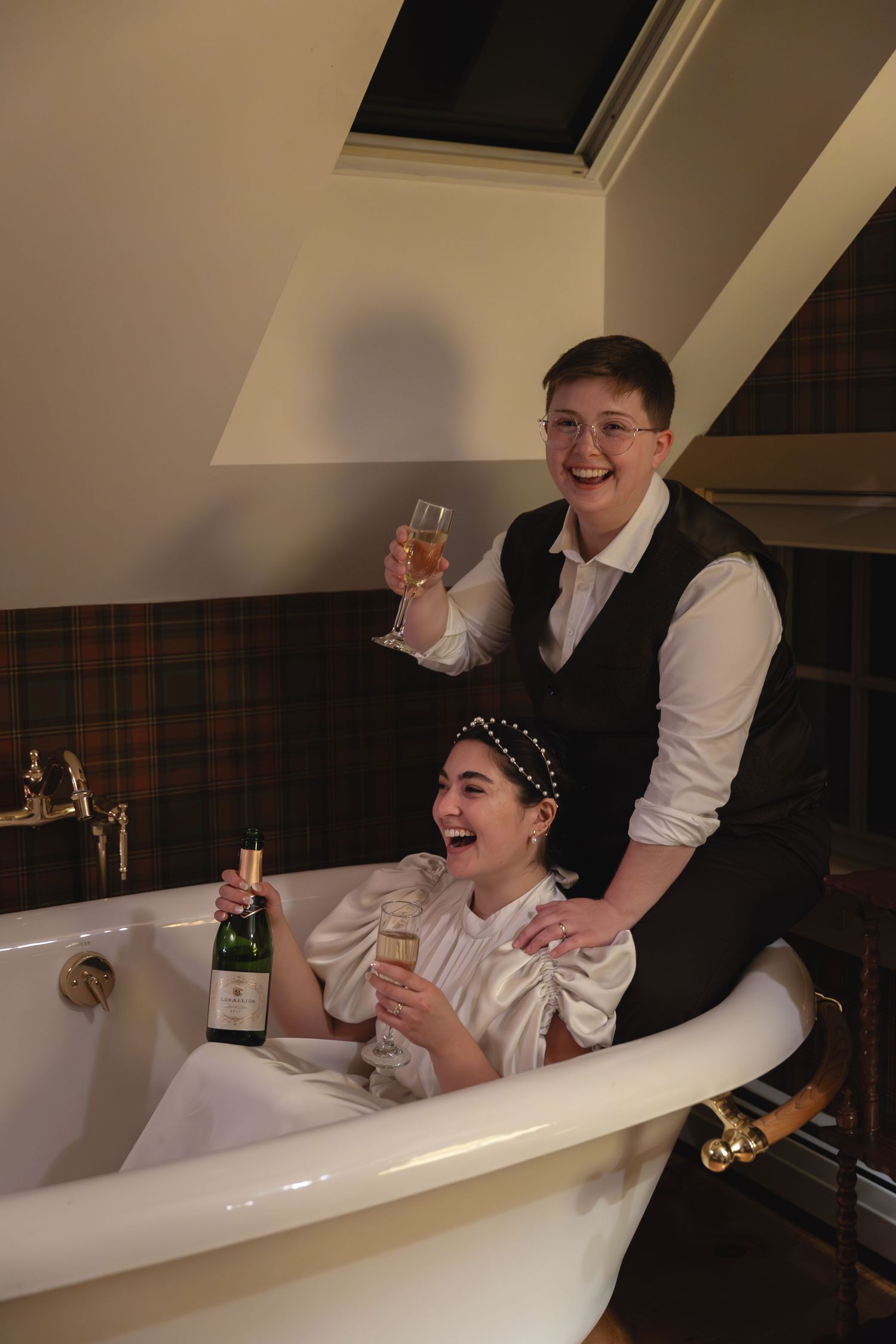 A celebratory moment with champagne in a clawfoot bathtub.