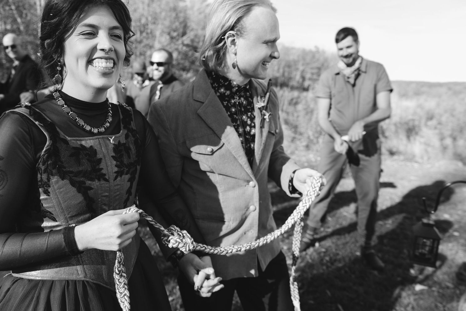 Black and white photo showing joyful candid moments at an outdoor celebration.