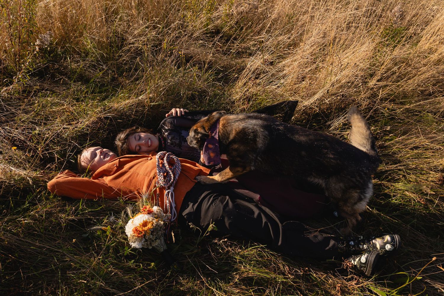 A person lies peacefully in tall grass during golden hour sunlight.