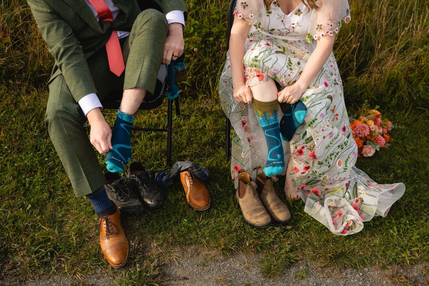 A series of feet and shoes lined up outdoors against a green natural background.