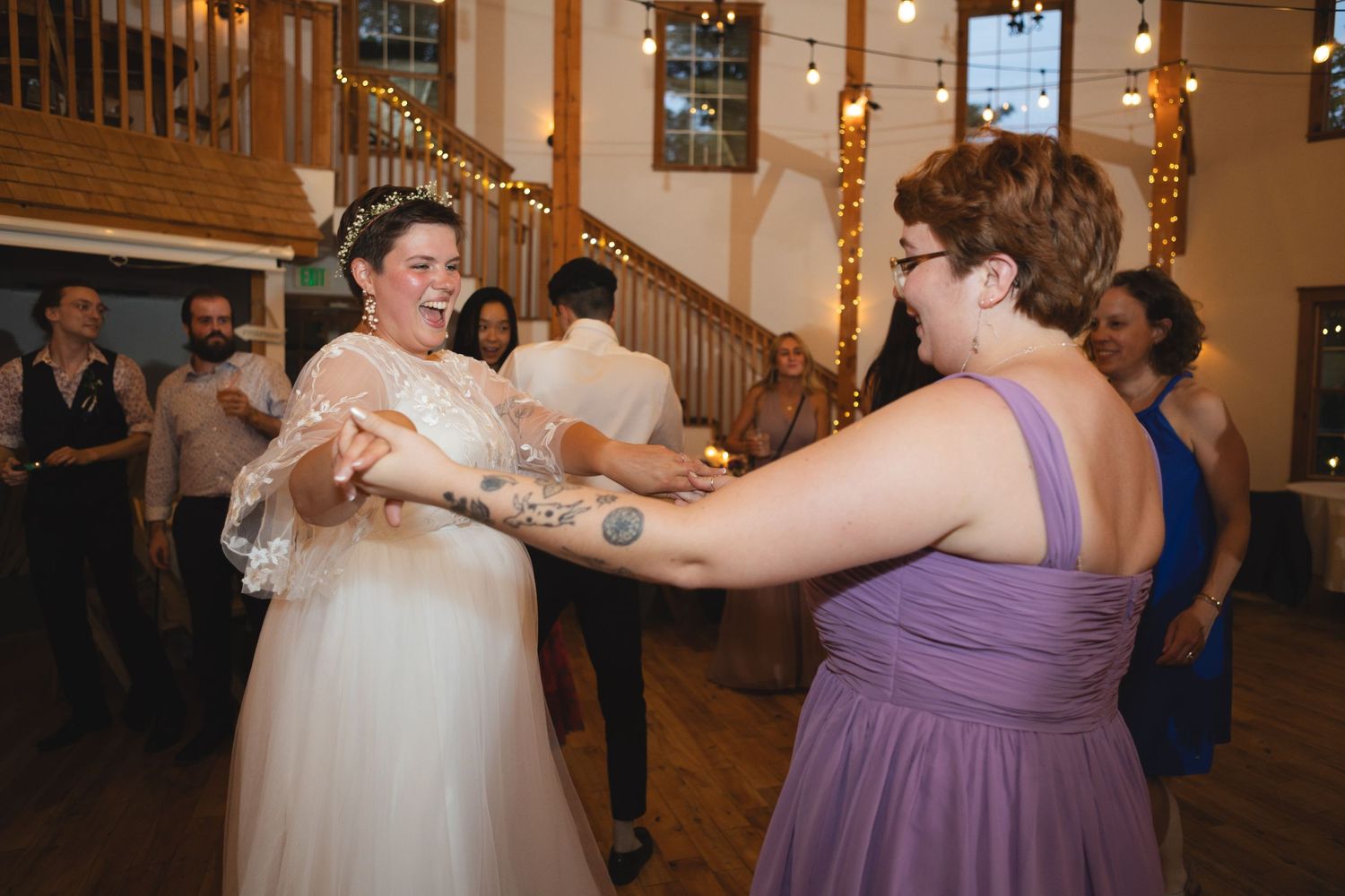 Wedding celebration with dancers in purple dresses enjoying the reception festivities.