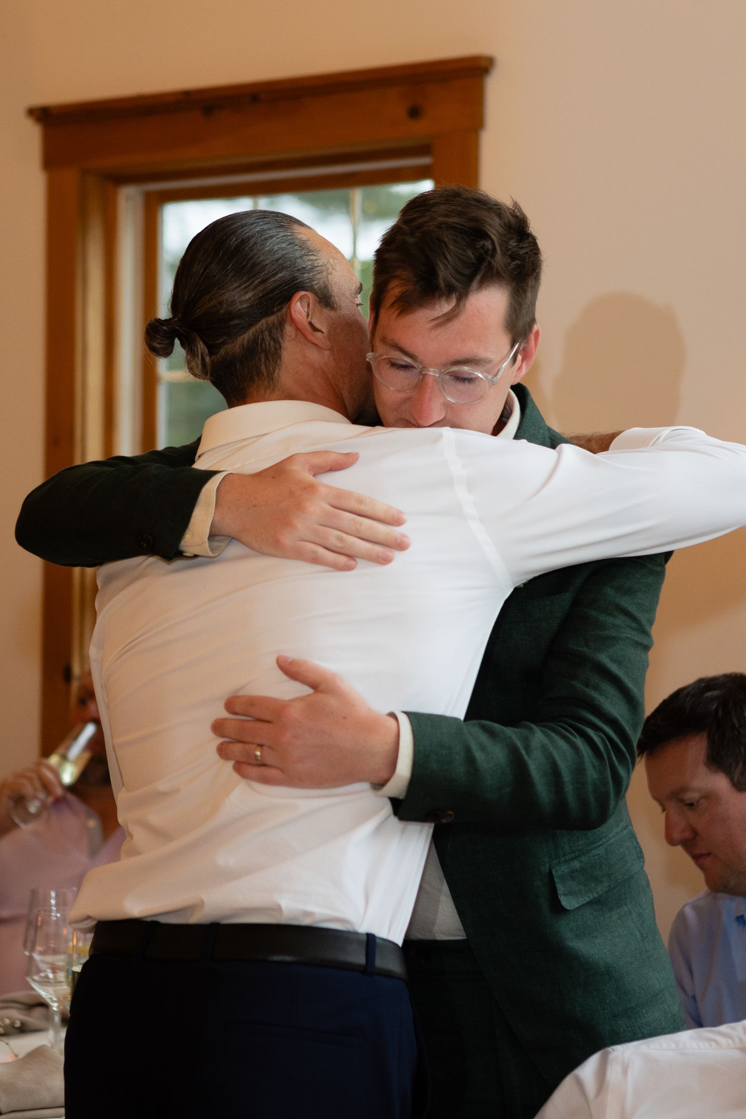 Two people sharing a warm embrace at a formal event.