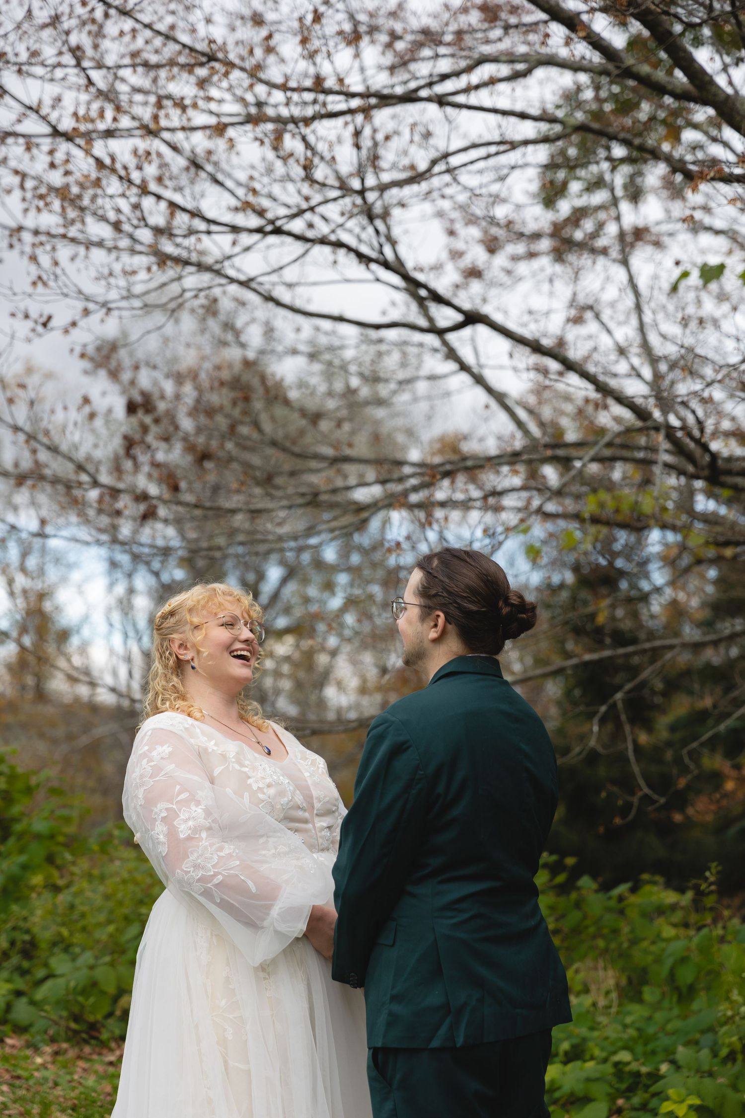 A joyful moment shared between two people during an autumn outdoor wedding.