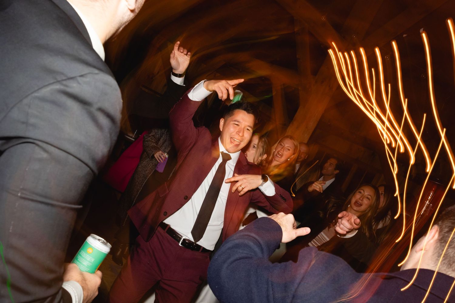 People dancing and celebrating at a nightclub with motion blur and warm lighting effects in the background.