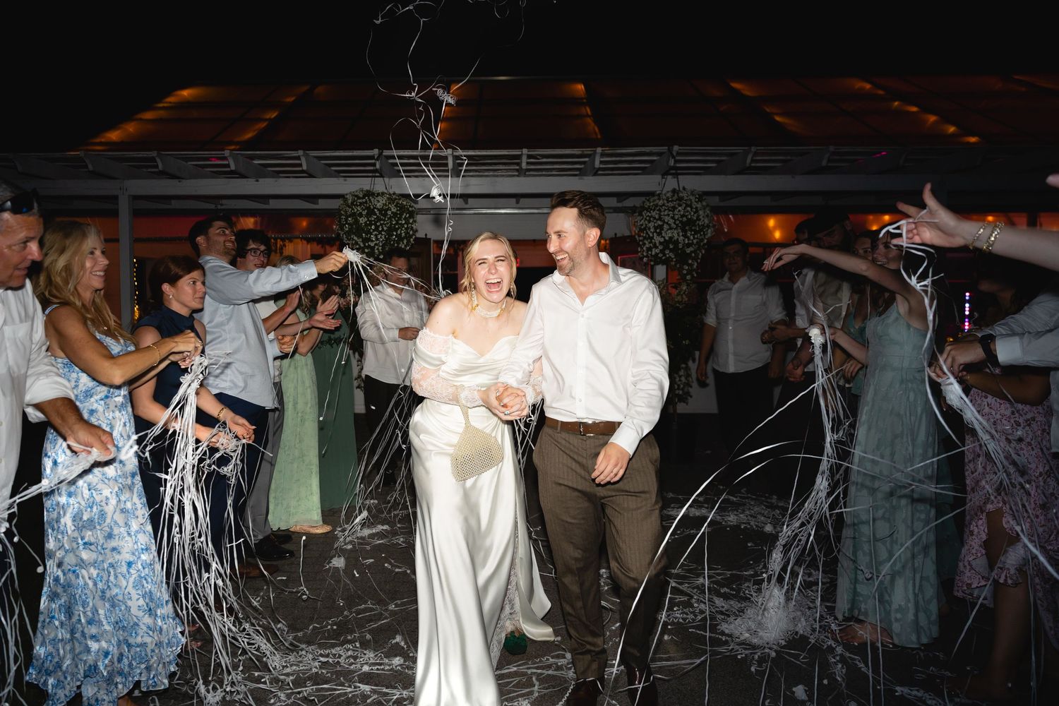 People dancing and enjoying themselves at a crowded indoor concert venue with dim lighting.