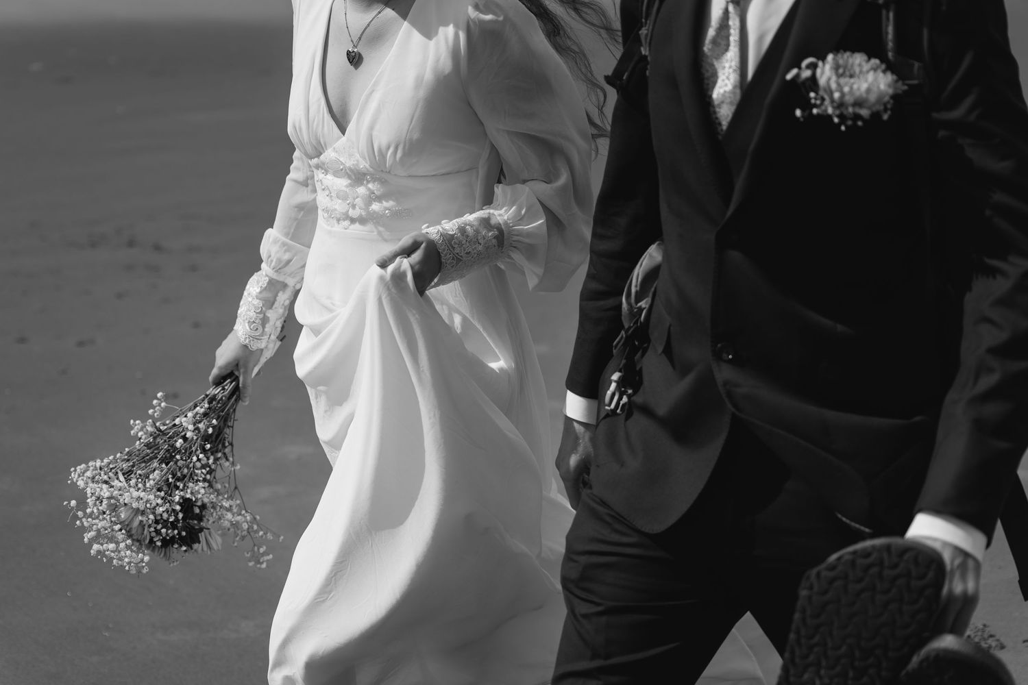 A bride and groom share a tender moment during their wedding ceremony in black and white photography.
