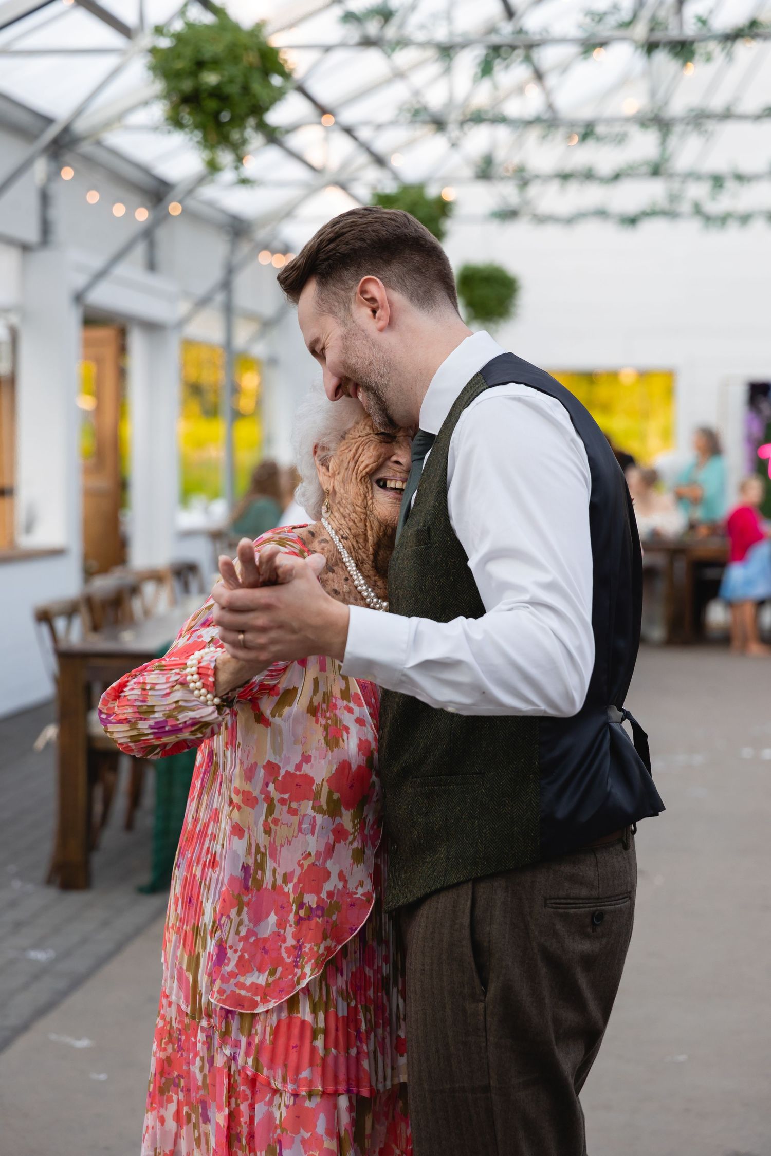 A couple in formal attire dance together in an elegant venue with a romantic dip sequence.