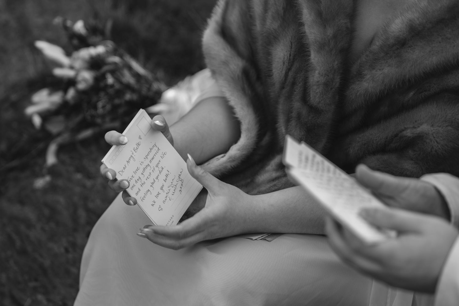 Black and white photo of hands holding a handwritten letter or note.