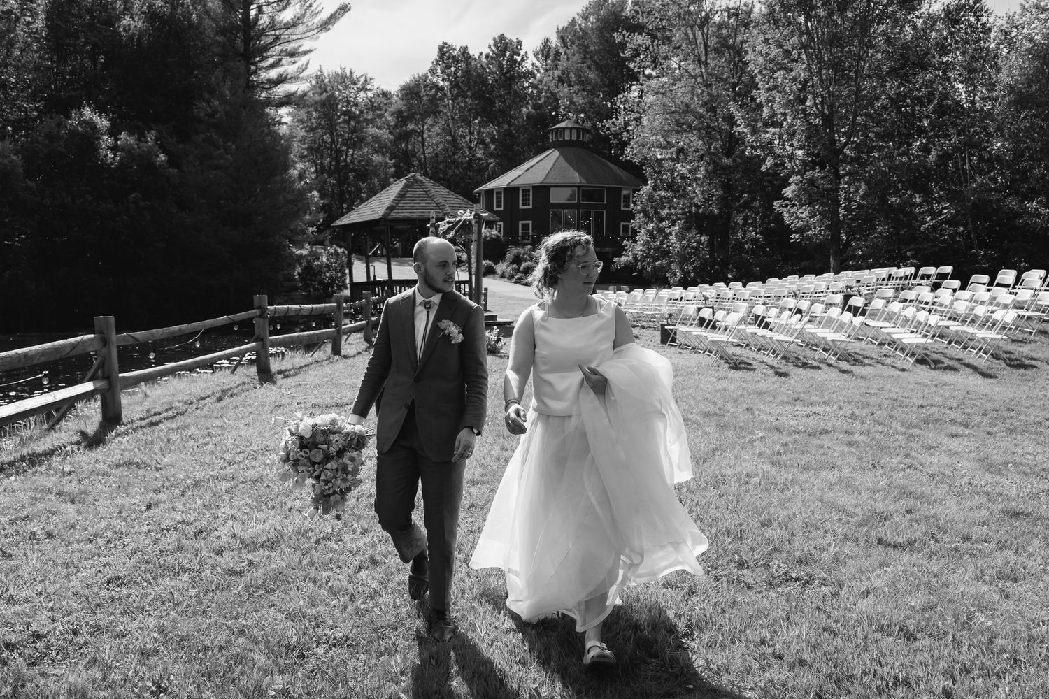 A series of black and white wedding photos showing a couple walking outdoors in a rustic setting with wooden fences.