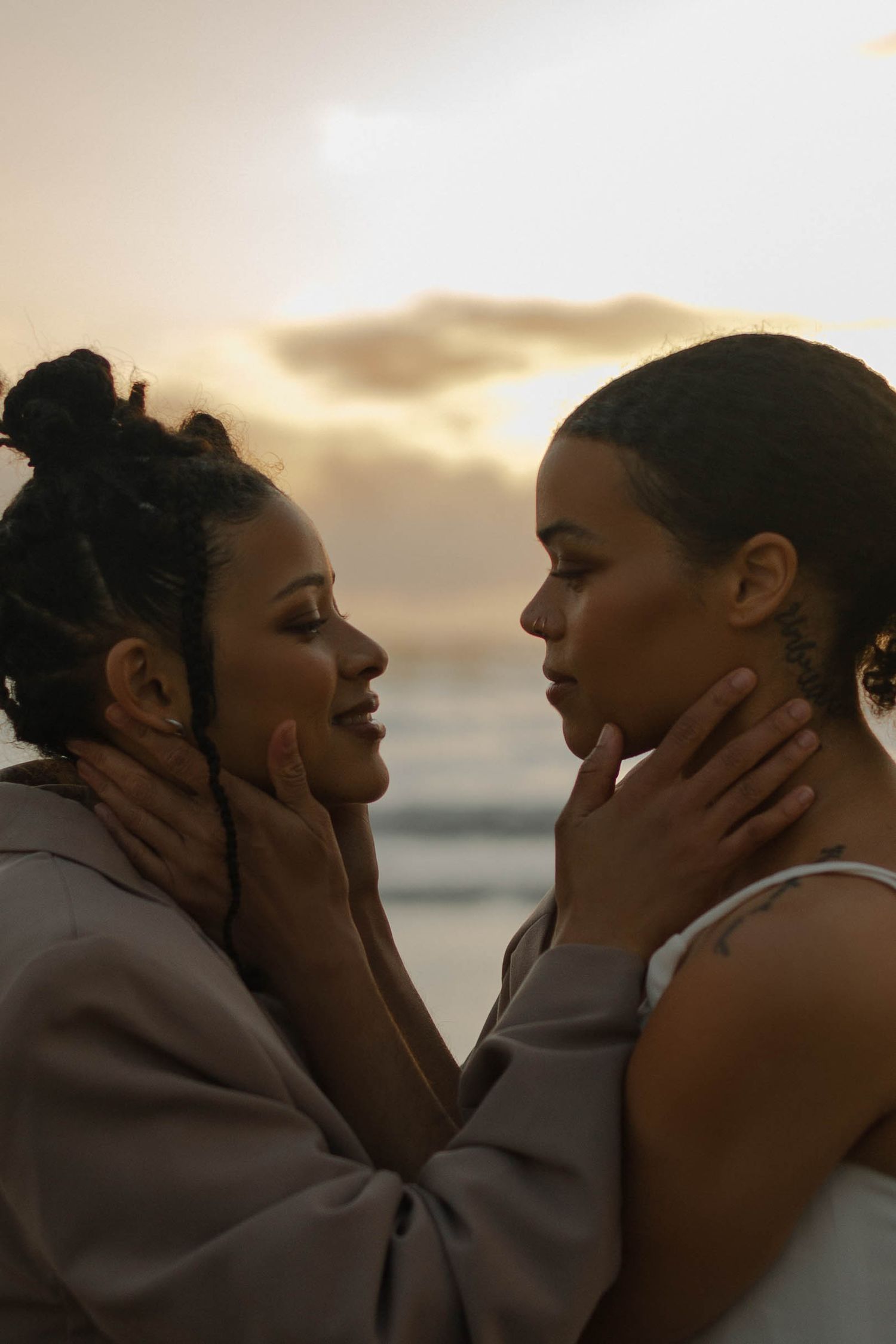 A tender moment between a couple in love during a sunset beach photoshoot.