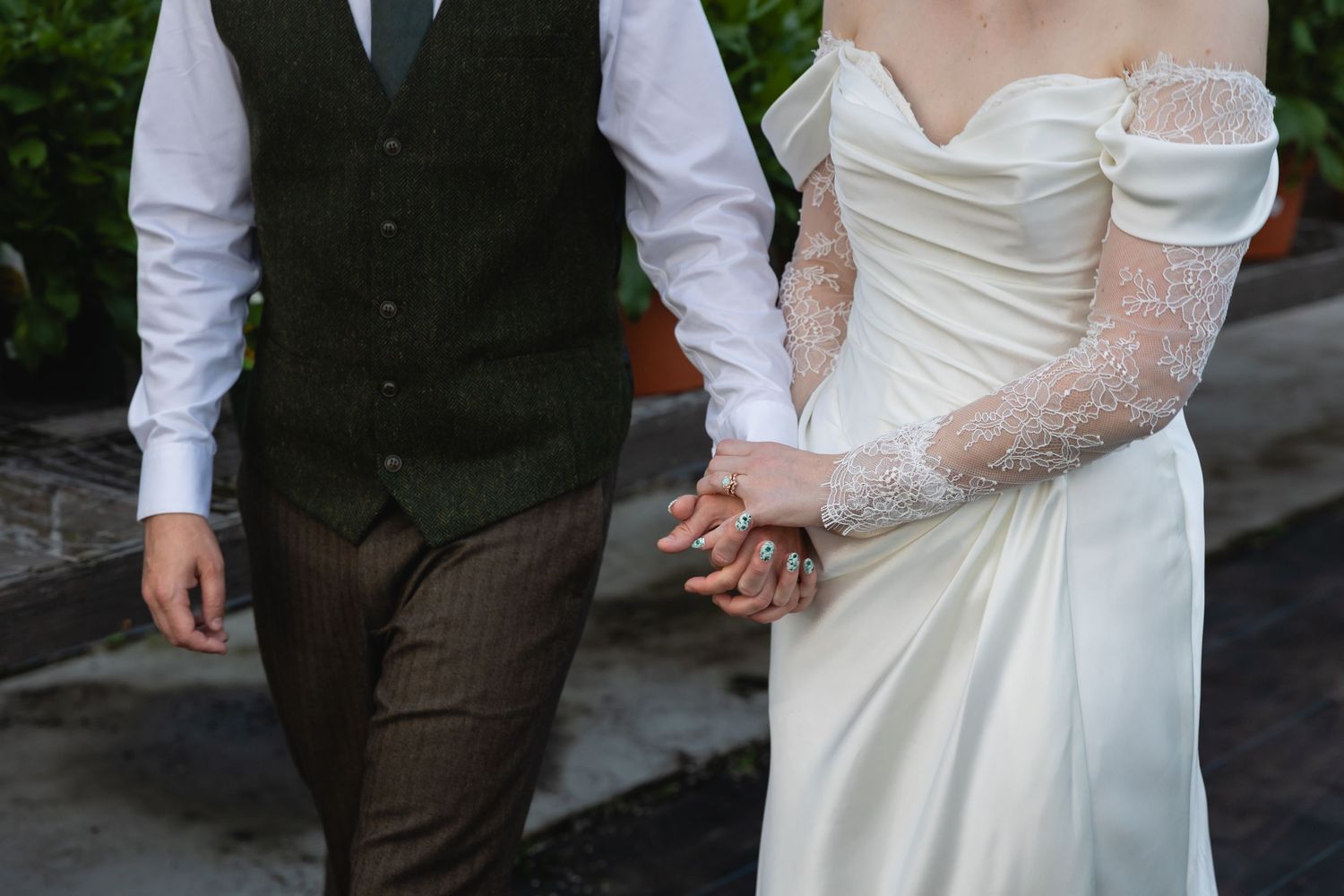 Close-up detail shots of a bride and groom in formal wedding attire showing hands, dress fabric and suit details.