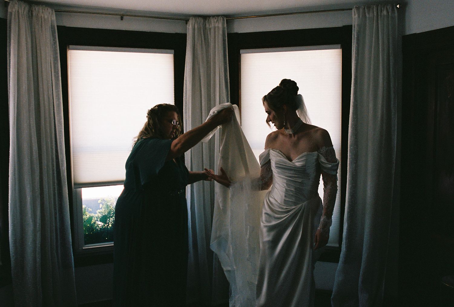 A series of dark silhouettes against windows in a room with curtains showing movement and interaction.