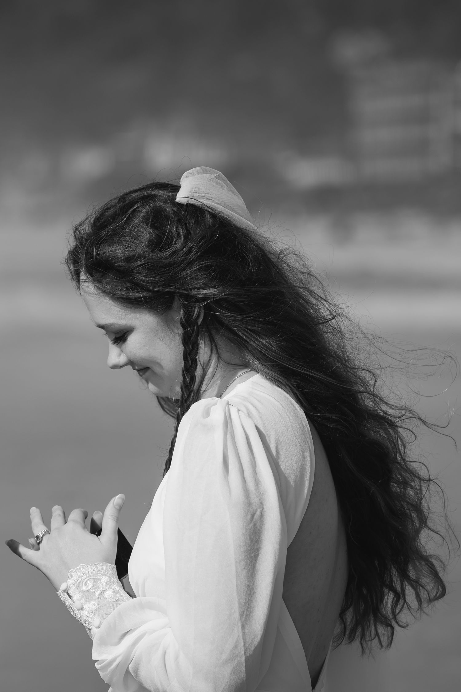 A person with long dark hair in a white shirt is shown in a black and white artistic portrait series.