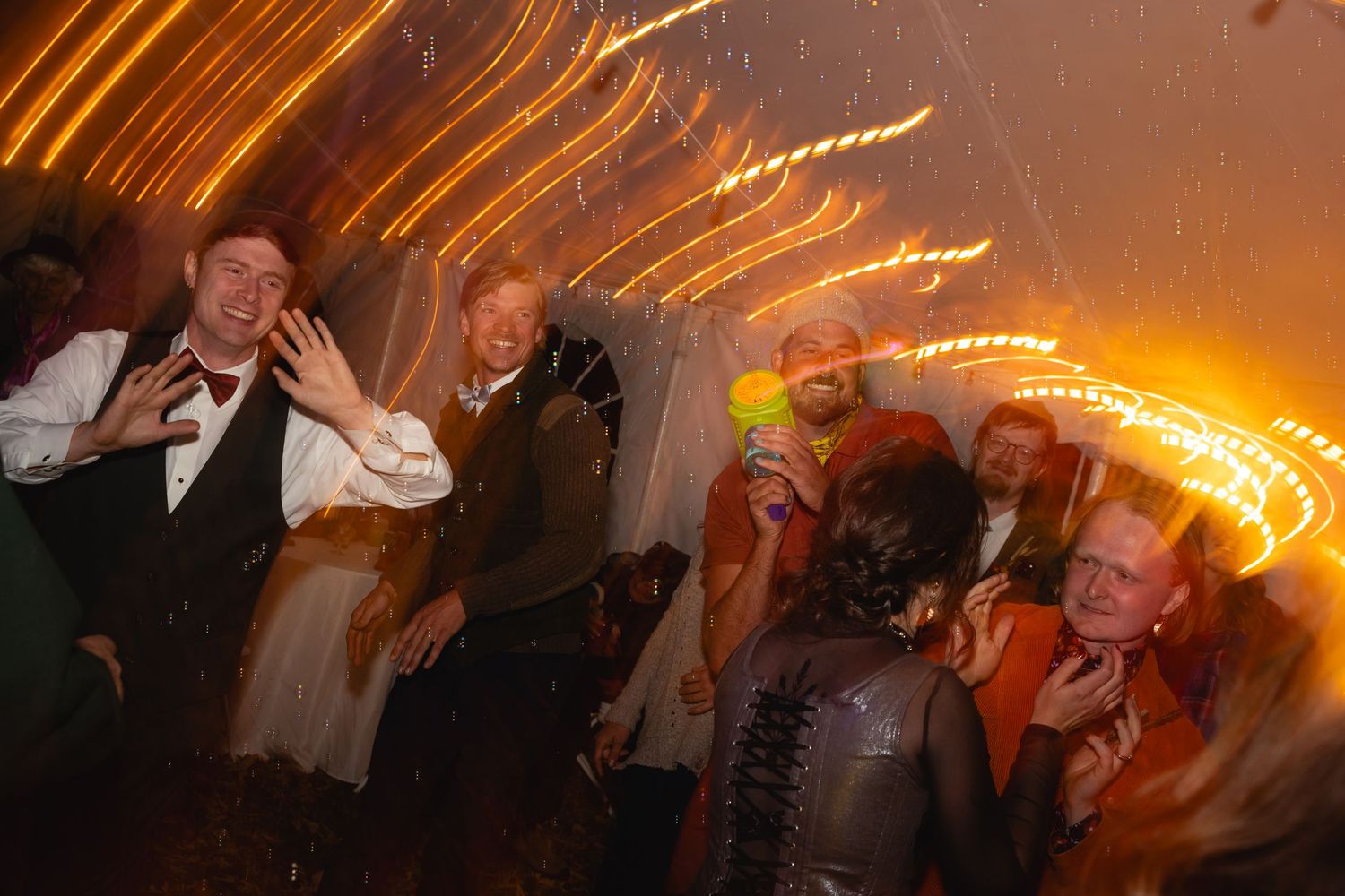 A motion-blurred series of party photos showing people dancing and celebrating in a dimly lit venue with warm lighting.