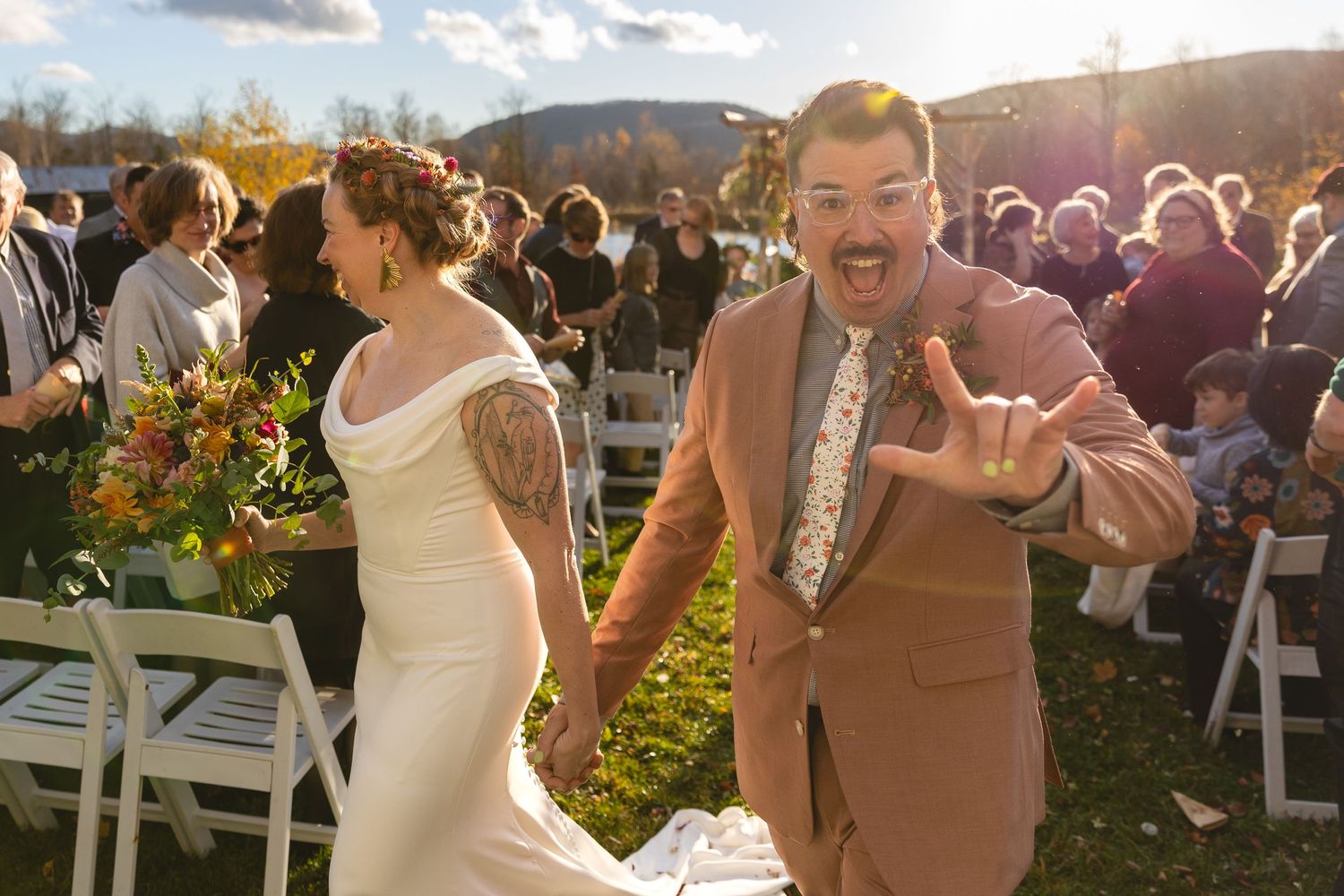Joyful couple celebrates during their outdoor wedding ceremony at golden hour.
