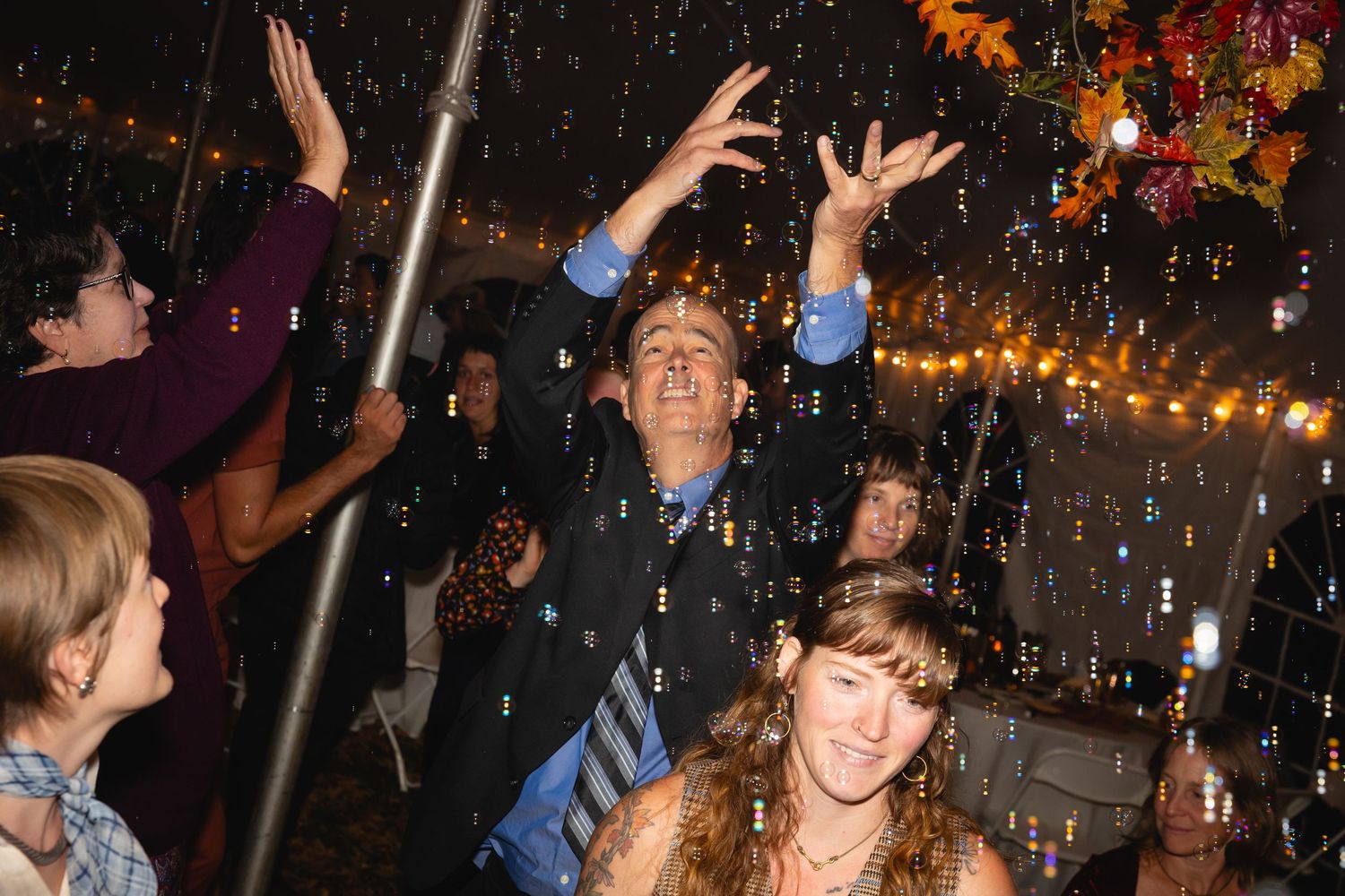 People dancing and celebrating at a lively nightclub party with colorful lights and confetti in the air.