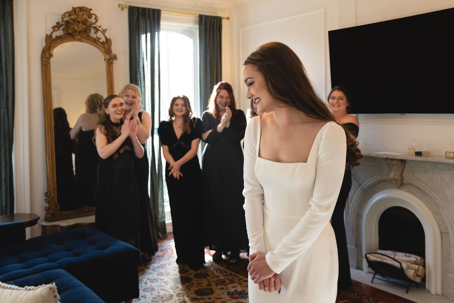 A heartwarming moment captured as a person in white receives reactions from guests in black dresses.