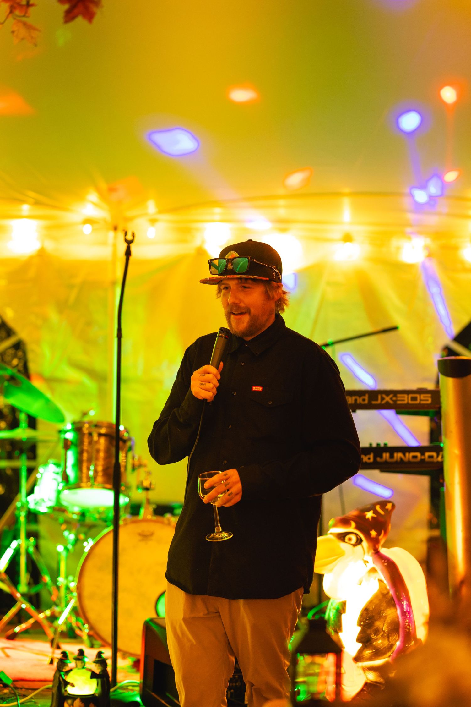 Concert performer on stage with colorful yellow and green lighting effects during a live music performance.