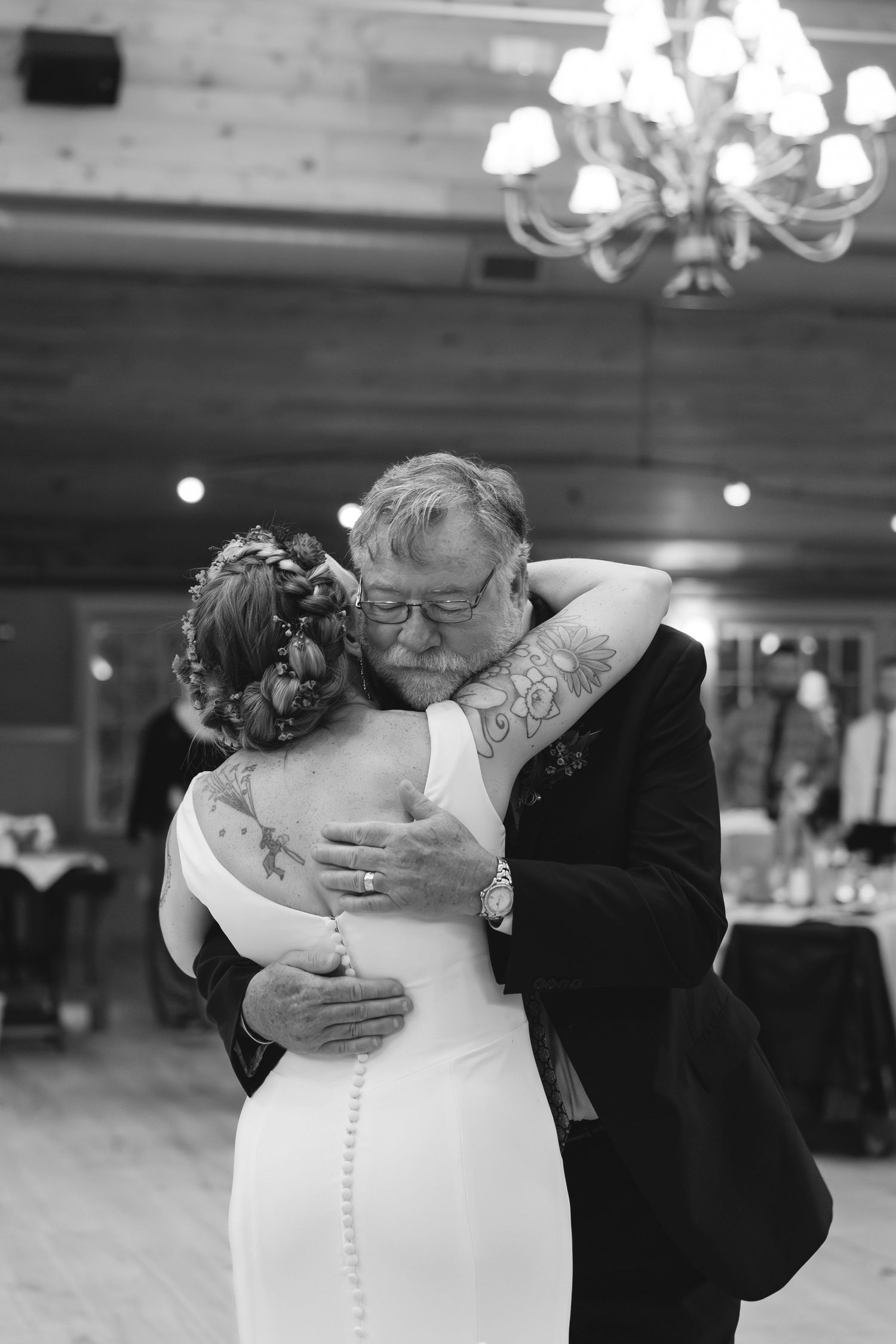 An emotional dance moment captured in black and white under a crystal chandelier.