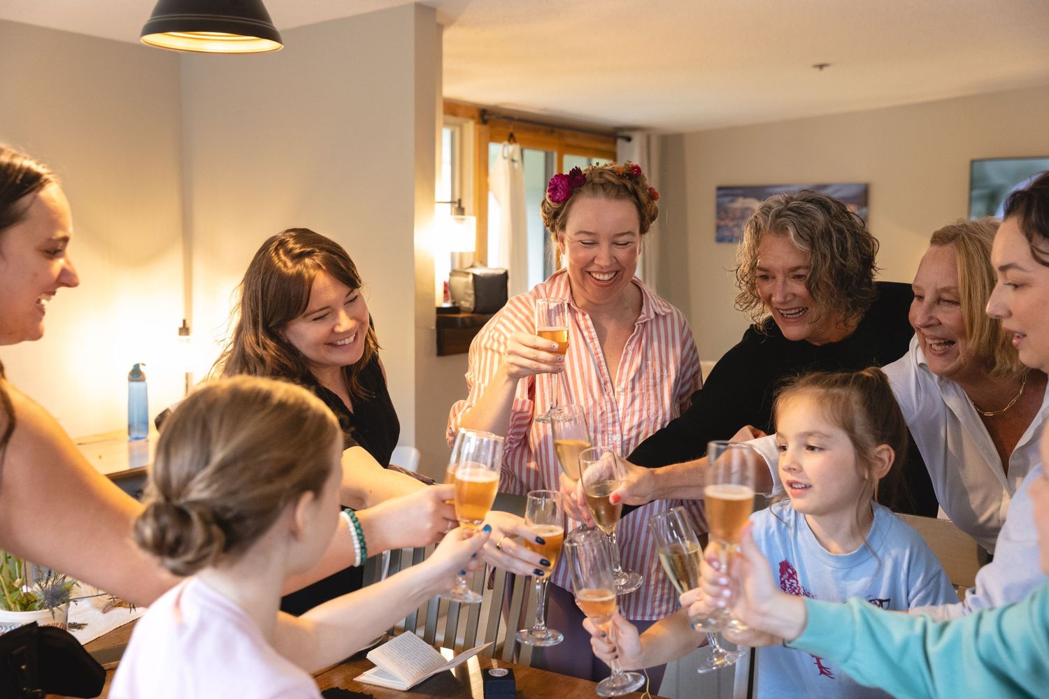 Group raising glasses in celebratory toast during gathering.