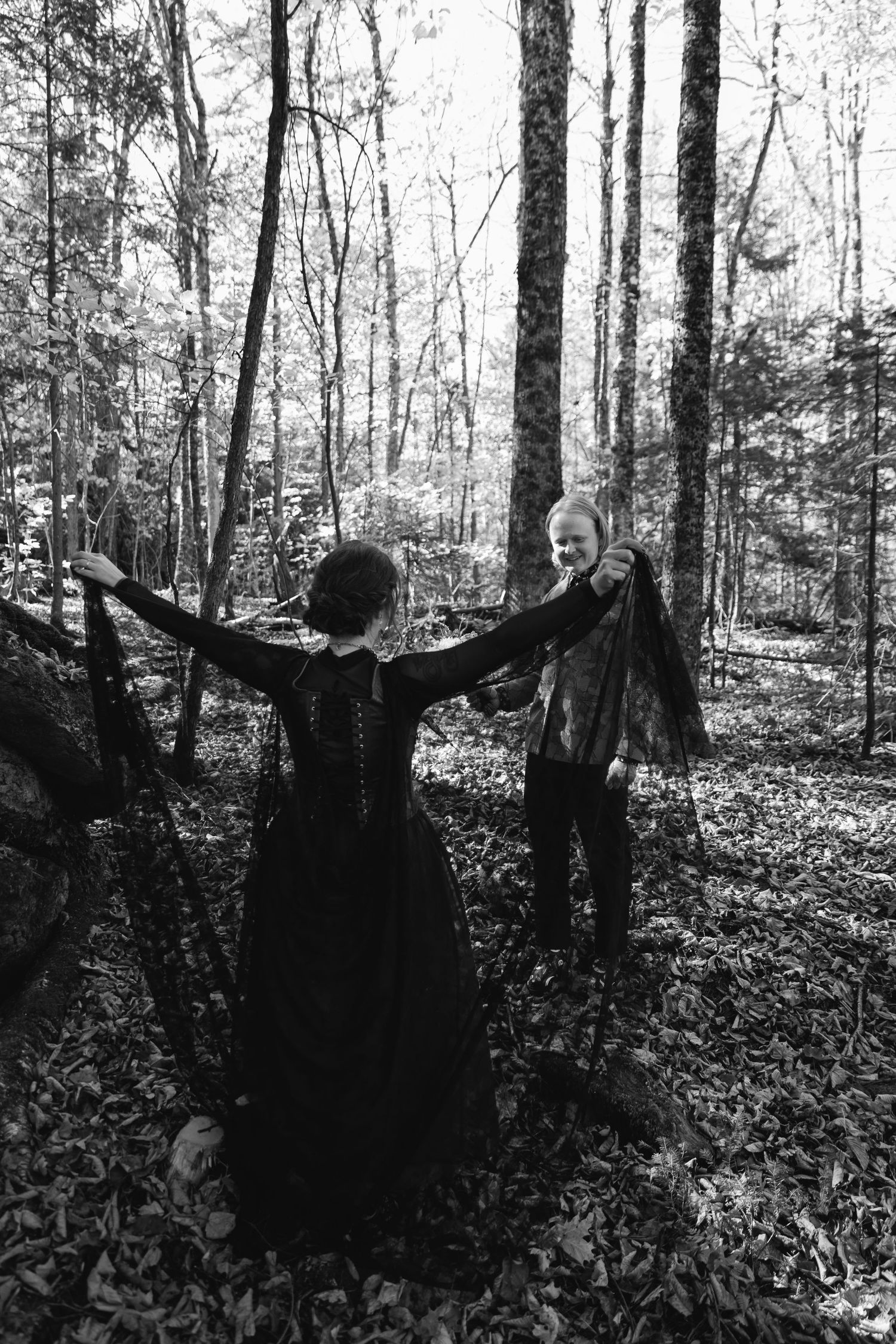 A sequence of black and white photos showing a figure in dark clothing with outstretched arms in a misty forest setting.
