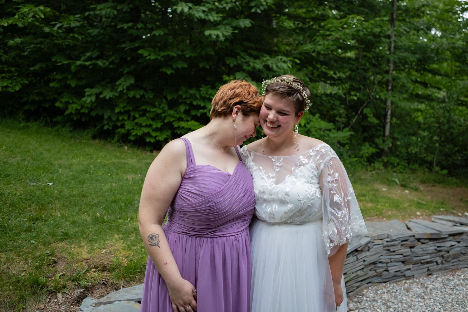 Wedding photos outdoors with bride in white dress and guest in purple dress against green foliage.