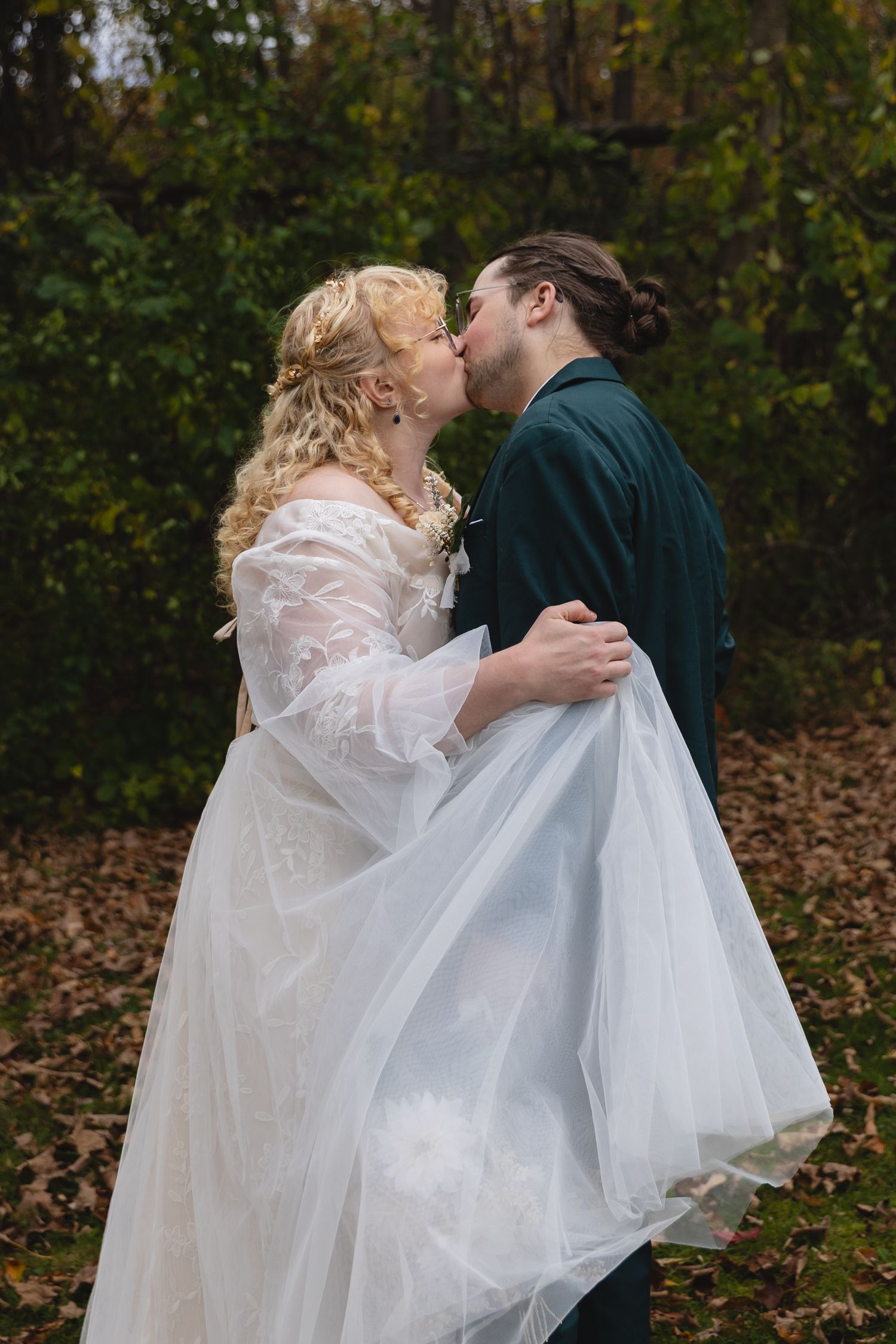 A romantic autumn wedding moment captured in front of fall foliage.