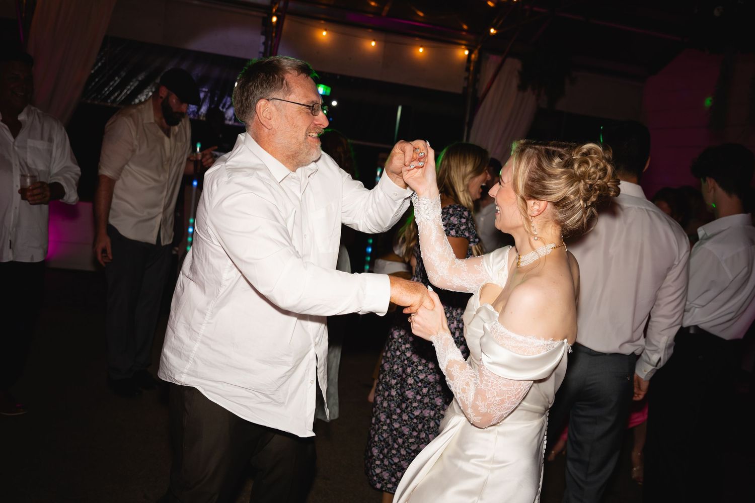 Couples dance together at a formal evening reception with warm lighting and festive atmosphere.
